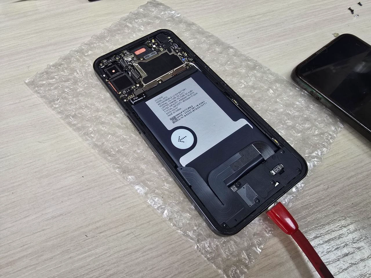 Снята задняя крышка Nothing Phone 1 — видна начинка и материнская плата